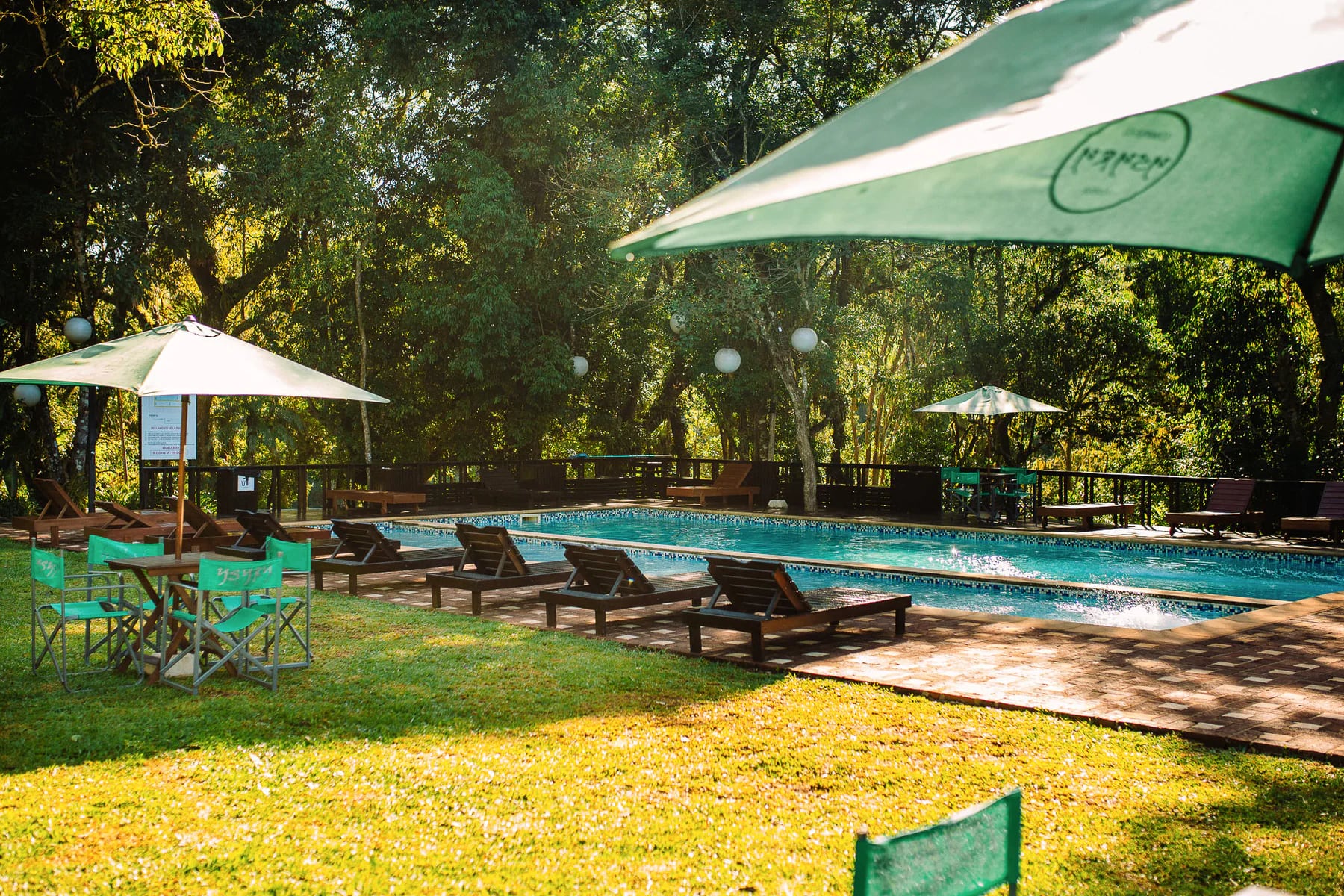 Reposeras, sombra y piscina en el balneario de Complejo Ysyry